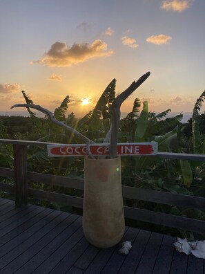 A wooden structure with a sign reading 'COCOA CAFE' and a view of the sunset.