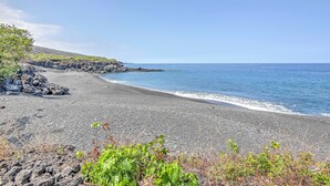 A beach with a rocky shoreline and a clear blue sky.