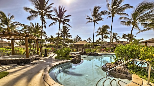 A pool area with palm trees, a pergola, and a building in the background. - Luxury Mauna Lani Resort Villa - Beach Access! (Kamuela)