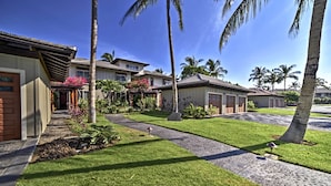 A residential area with houses, a well-maintained lawn, and palm trees. - Luxury Mauna Lani Resort Villa - Beach Access! (Kamuela)