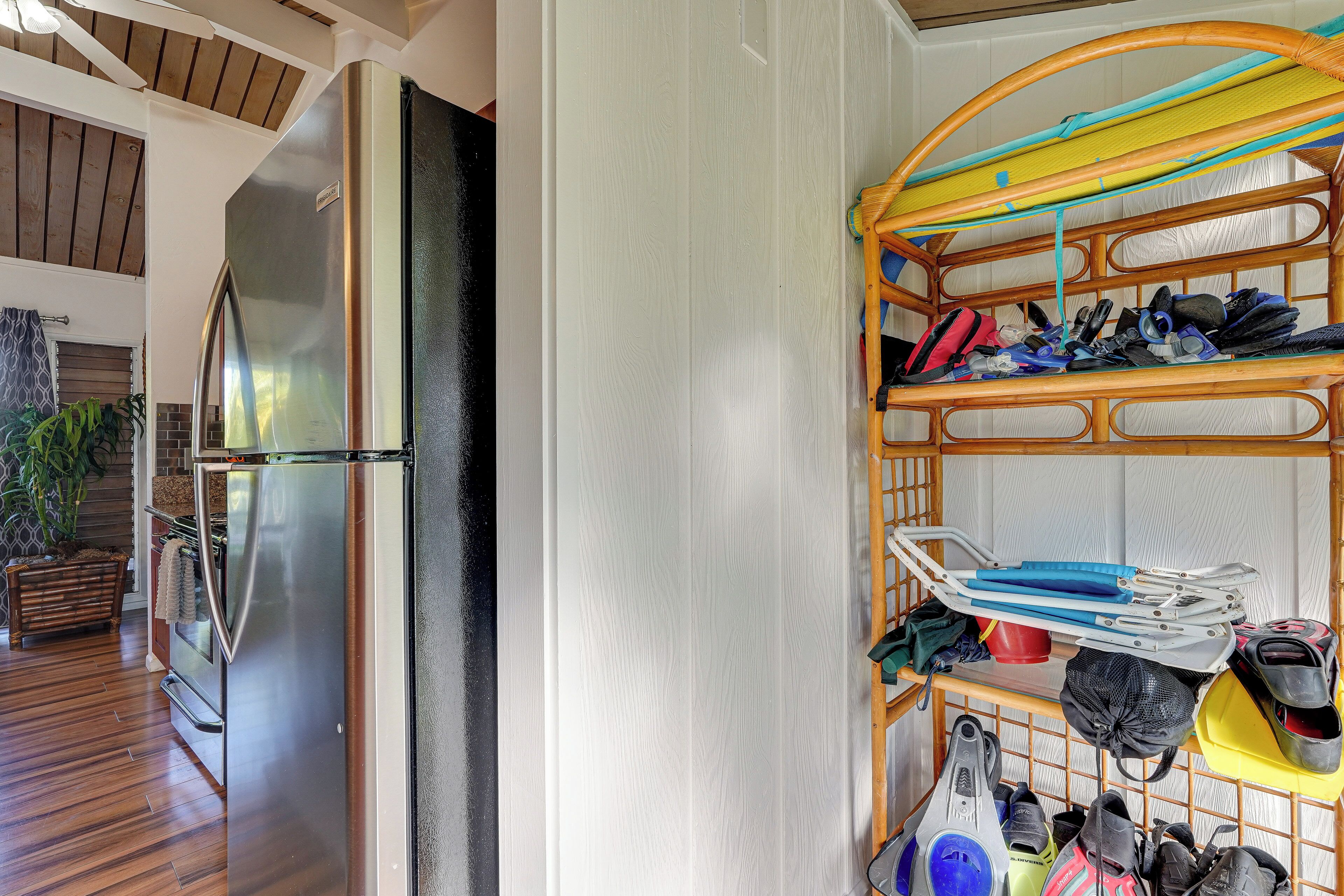 A kitchen with a stainless steel refrigerator, wooden flooring, and a built-in bench.