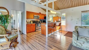A spacious kitchen with wooden cabinets, a microwave, and a bar area.