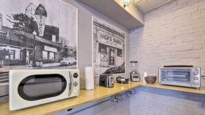 A kitchen with a white brick wall, a wooden countertop, a vintage Galanz microwave, a toaster, and a blender. - Charming Springfield Apt < 2 Mi to Downtown! (Springfield)