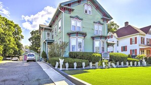 A green Victorian-style house with a well-maintained lawn and a driveway. - Charming Springfield Apt < 2 Mi to Downtown! (Springfield)
