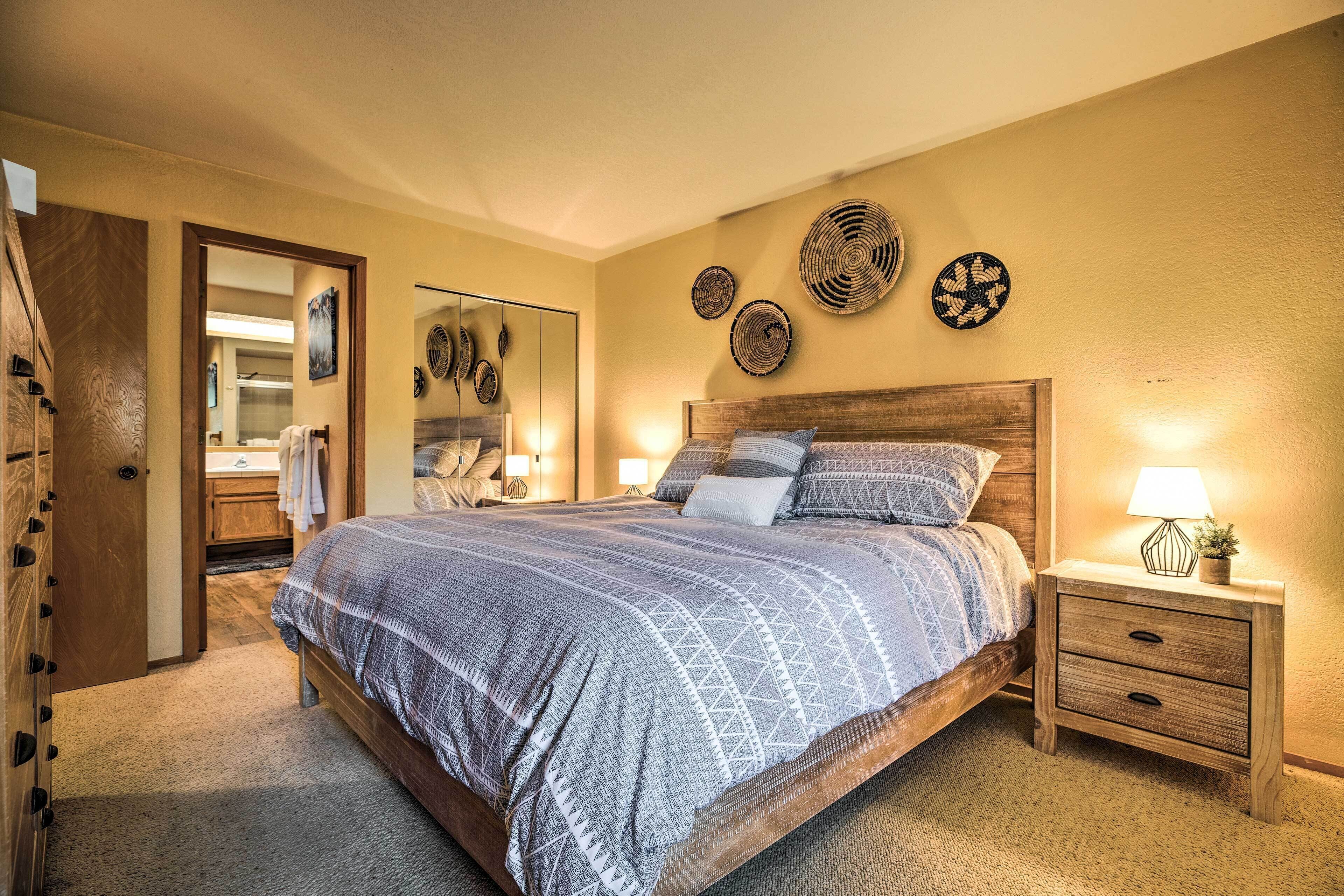 A bedroom with a large bed, wooden headboard, bedside tables, and wall decor.