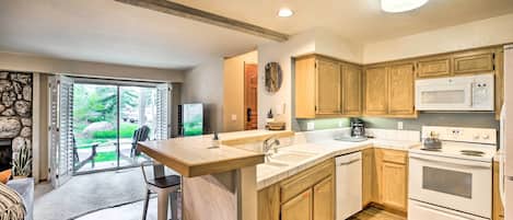 A modern kitchen with wooden cabinets, a large island, and a built-in oven.