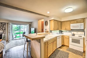 Une cuisine moderne avec des meubles en bois, un grand îlot central et un four encastré.