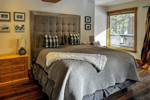A bedroom with a large bed, a wooden dresser, and a window with a view of trees. - 2 Blocks to Lake Tahoe! Group Gem w/ Hot Tub (Incline Village)
