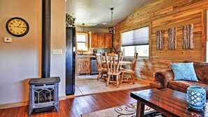 A cozy living room with a fireplace, wooden dining table, and a sofa.