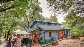 A rustic cabin with a porch, outdoor seating, and a fenced yard. - Secluded Placerville Cabin w/ Deck: Walk to River! (Placerville)