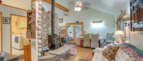 A cozy living room with a fireplace, a sofa, and a dining area.