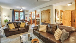 A spacious living room with two leather sofas, a glass coffee table, and a ceiling fan. - < 1 Mi to Hot Spring: Condo in Pagosa Springs! (Pagosa Springs)