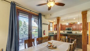 A dining area with a table set for four, wooden chairs, a ceiling fan, and a view of the outdoors through a glass door. - < 1 Mi to Hot Spring: Condo in Pagosa Springs! (Pagosa Springs)