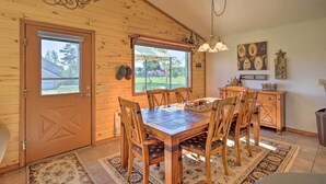 Un interior de madera con una mesa de comedor, sillas y una araña.