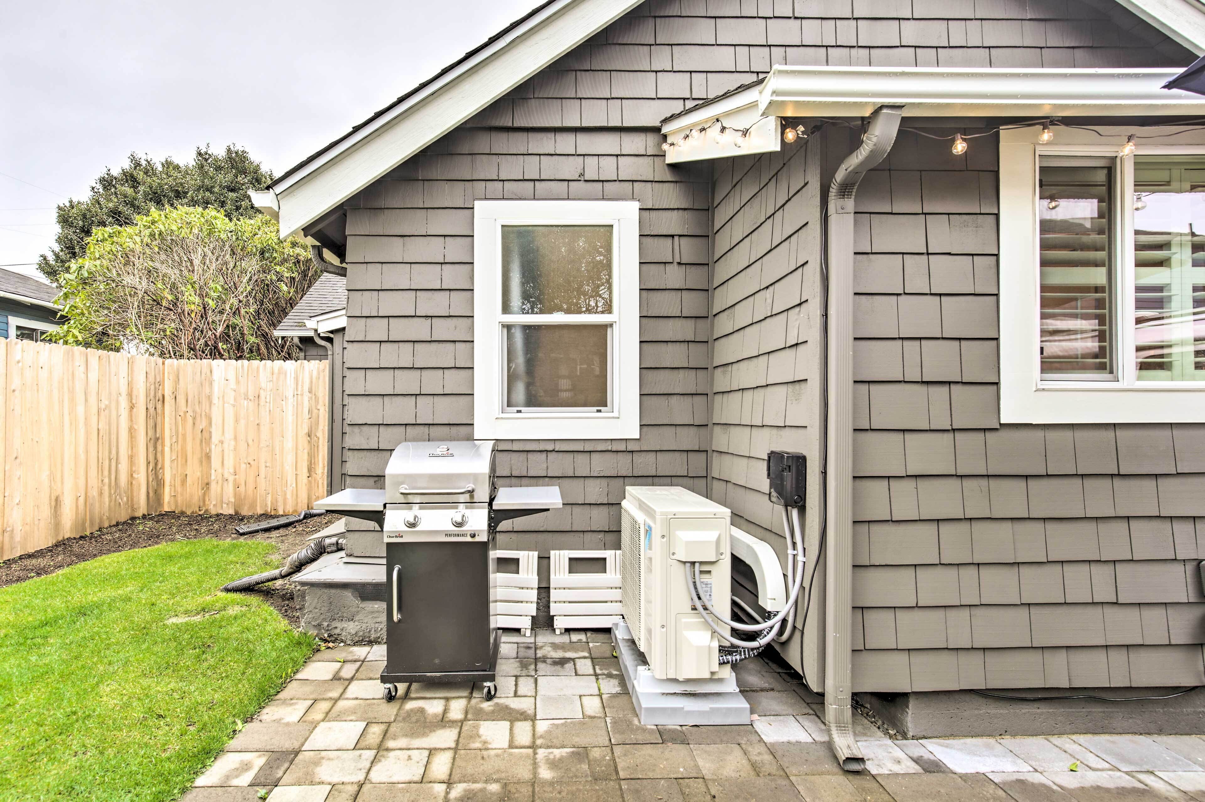 Une maison dotée d’un patio comprenant un barbecue, un chauffe-eau et une fenêtre.