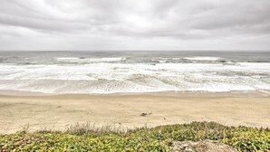 A beach with waves crashing onto the shore under an overcast sky. - Chic Lincoln City Retreat on Oregon Coast (Lincoln City)