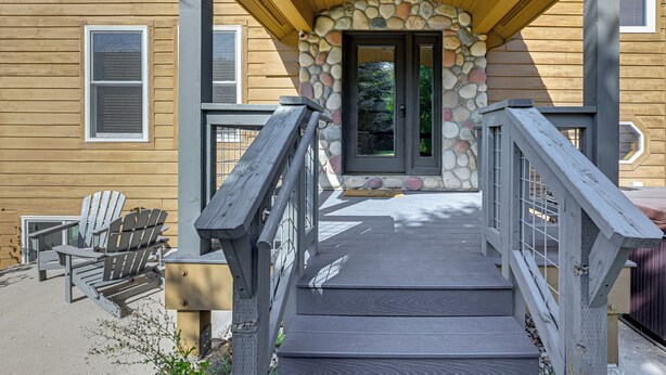 Una casa de madera con un arco de piedra que da a una puerta oscura.