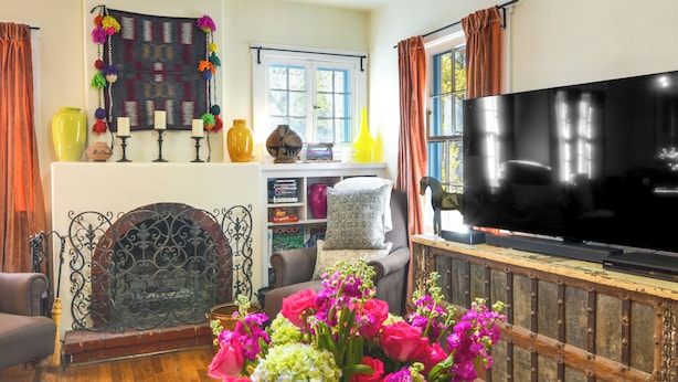 A living room with a fireplace, a television, and a bookshelf. - Cozy Adobe Casita: 1 Mile to Santa Fe Plaza! (Santa Fe)