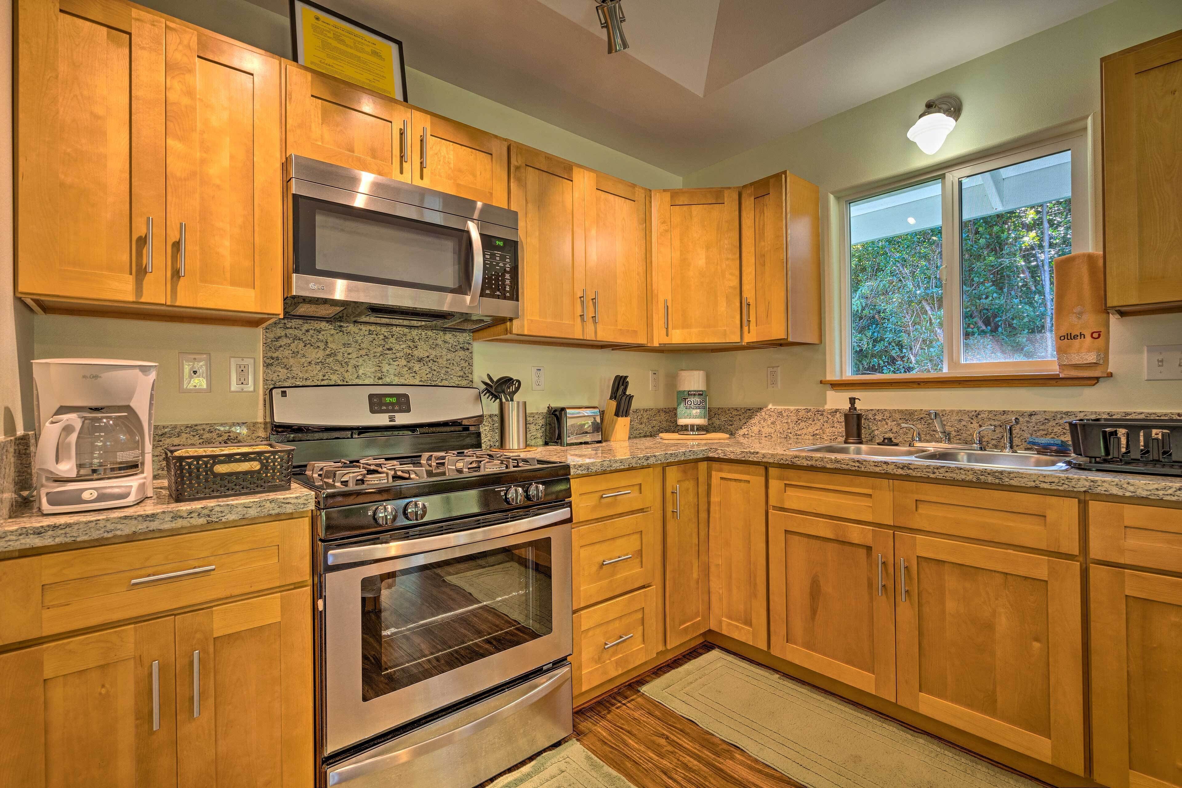 A kitchen with wooden cabinets, a stainless steel microwave, a gas stove, and a built-in oven.