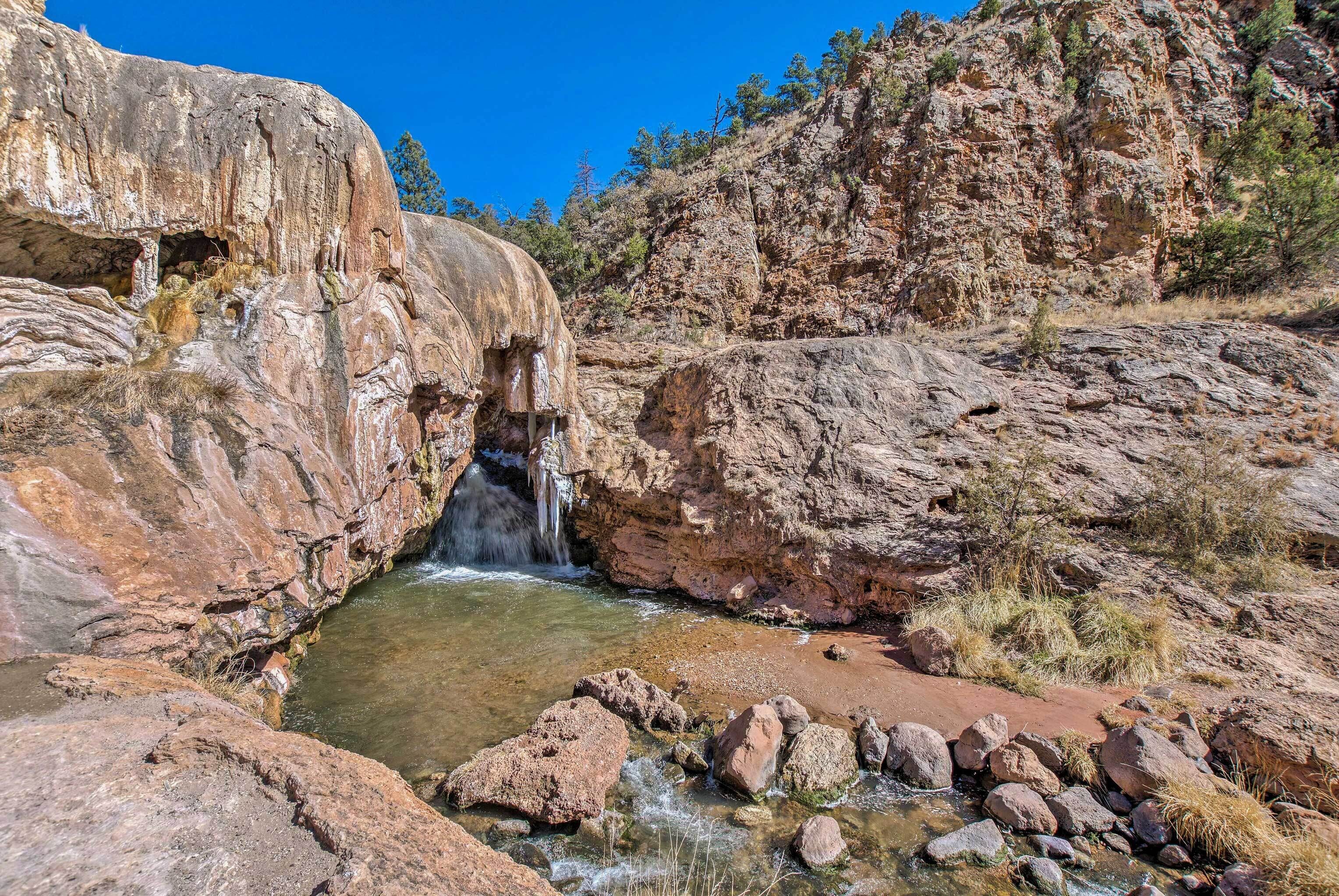 Une formation rocheuse naturelle avec une petite cascade et de l’eau claire.