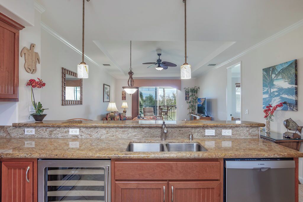 A kitchen with granite countertops, stainless steel appliances, and pendant lighting.