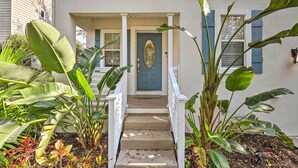 A house with a front porch, a blue door, and a staircase leading to the entrance. - St Augustine Home w/ Swim Spa & Marsh Views! (St. Augustine)
