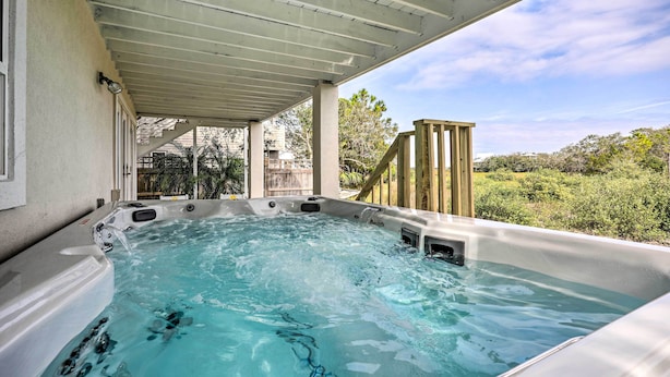 A hot tub under a covered patio with a view of the surrounding landscape. - St Augustine Home w/ Swim Spa & Marsh Views! (St. Augustine)