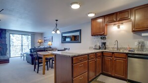 A kitchen with wooden cabinets, a granite countertop, and a dishwasher. - Winter Park Condo w/ Hot Tubs, 4 Mi to Ski Resort! (Winter Park)