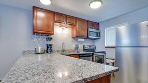 A kitchen with granite countertops, wooden cabinets, stainless steel appliances, and under-cabinet lighting. - Winter Park Condo w/ Hot Tubs, 4 Mi to Ski Resort! (Winter Park)