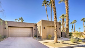 A two-story house with a garage, palm trees, and a landscaped driveway. - Quiet Palm Desert Condo: Workspace & Pool Access! (Palm Desert)