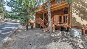 A two-story building with a wooden deck and stairs leading to the entrance. - Spacious Ruidoso Retreat w/ Hot Tub & 2 Kitchens! (Ruidoso)