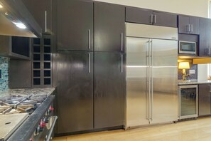 Une cuisine moderne équipée d’appareils électroménagers en acier inoxydable, d’une cuisinière à gaz et d’un four à micro-ondes.