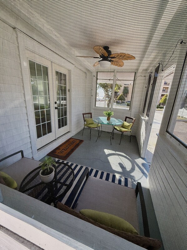 A room with a balcony, a ceiling fan, a small table with chairs, and a potted plant. - Charming Sebring Historic Registry Home Near Circle and Across from Lake Jackson (Sebring)