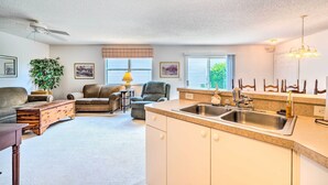 A compact living space with a kitchenette, a ceiling fan, a dining area, and a view of the outdoors. - Sunny Home in The Villages w/ Lanai & Pool Access! (The Villages)