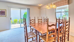 A dining area with a wooden table and chairs, a ceiling light, and a view through a glass door. - Sunny Home in The Villages w/ Lanai & Pool Access! (The Villages)