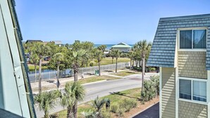 A view of a street with a sidewalk, palm trees, and a body of water in the background. - Walk to Beach! Isle of Palms Condo w/ Pool Access (Isle of Palms)
