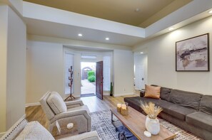 A spacious living room with a grey sofa, a patterned rug, and a coffee table with candles. - Bermuda Dunes Home w/ Private Pool, Patio & Grill! (Indio)