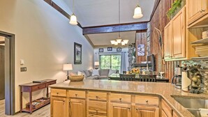 A kitchen with wooden cabinets, a granite countertop, and hanging pendant lights. - Condo w/ Pool + Hot Tub - Walk to DT Winter Park! (Winter Park)