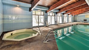 A swimming pool with a wooden ceiling and tiled walls, featuring a hot tub and a diving board. - Condo w/ Pool + Hot Tub - Walk to DT Winter Park! (Winter Park)