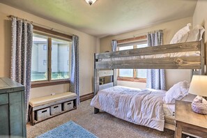 A bedroom with a bunk bed, a bench with storage drawers, a bedside table with a lamp, and a window with curtains. - 3-story Home w/ Balcony ~ 6 Mi to Winter Park! (Fraser)
