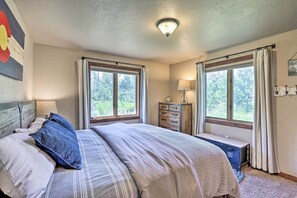 A bedroom with a bed, two windows, a dresser, a lamp, and a ceiling light. - 3-story Home w/ Balcony ~ 6 Mi to Winter Park! (Fraser)