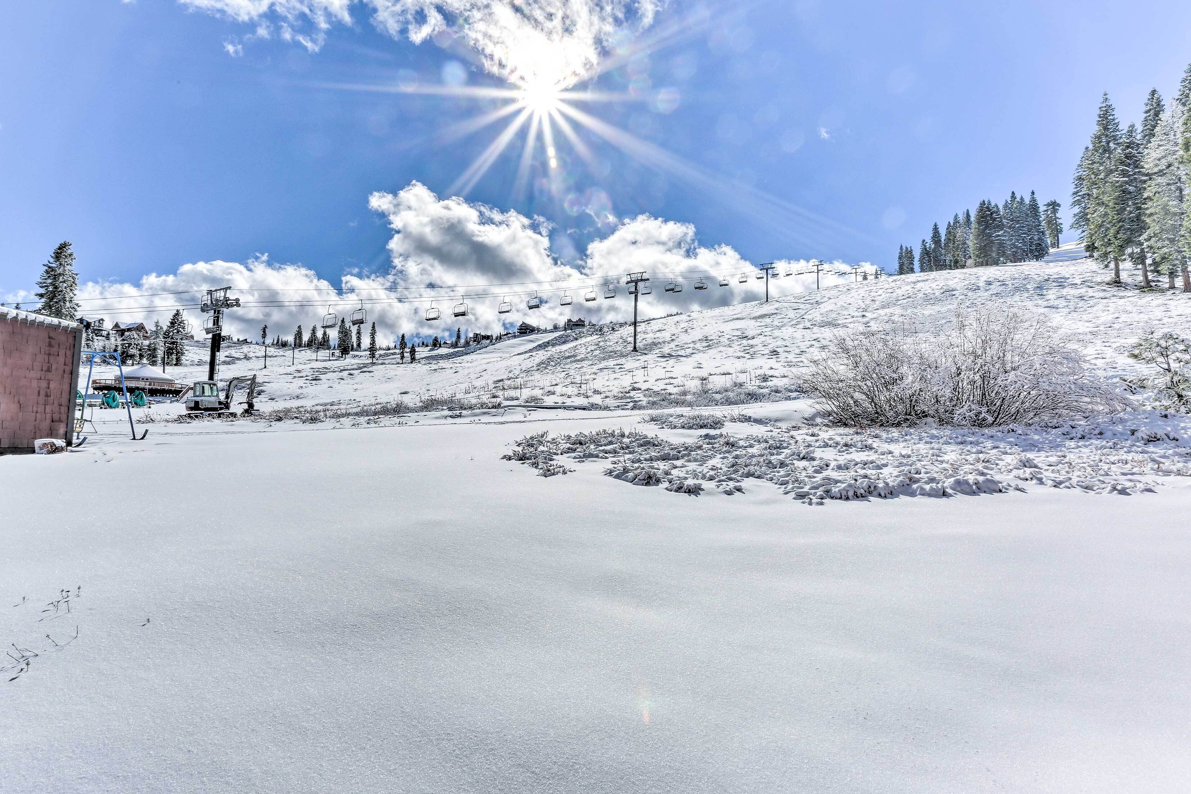 Paisaje nevado con telesilla, árboles y cielo despejado.