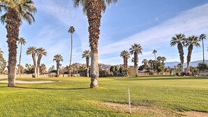 A golf course with palm trees and a clear sky. - Trendy Palm Desert Home w/ Patio & Pool Access (Palm Desert)