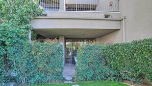 Ein Gebäude mit überdachter Eingangspartei, einer sichtbaren Treppe und einem gepflegten Garten mit trittfesten Pflastersteinen.
