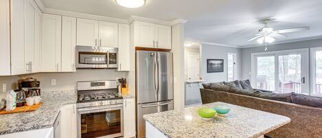 A modern kitchen with stainless steel appliances, a granite countertop, and a built-in oven.