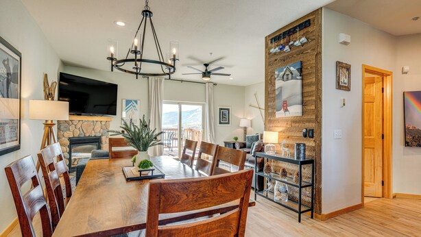 A spacious dining area with a wooden table and chairs, a ceiling fan, and a fireplace. - 8 Mi to Keystone: Mtn-view Ski Retreat! (Silverthorne)