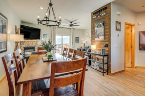 A spacious dining area with a wooden table and chairs, a ceiling fan, and a fireplace. - 8 Mi to Keystone: Mtn-view Ski Retreat! (Silverthorne)