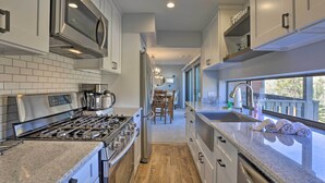 A modern kitchen with stainless steel appliances, a granite countertop, and a view of the balcony. - Ski, Shred & Tube: Mtn-view Condo in Silverthrone! (Silverthorne)