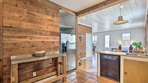 A kitchen with wooden walls, stainless steel appliances, and a dishwasher. - Contemporary San Antonio Home w/ Private Yard (San Antonio)