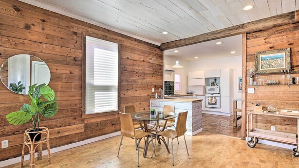 A wooden interior with a dining area, kitchen, and a large mirror. - Contemporary San Antonio Home w/ Private Yard (San Antonio)